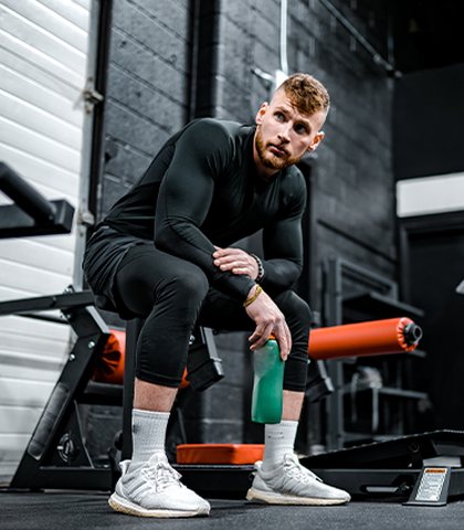 Fitness coach resting between sets in the gym